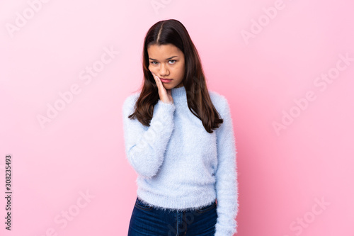 Young Colombian girl over isolated pink background unhappy and frustrated © luismolinero