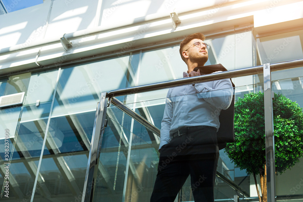 Portrait of a businessman in suit are standing on the background of glass offices. Portrait of a businessman in suit are standing on the background of glass offices.