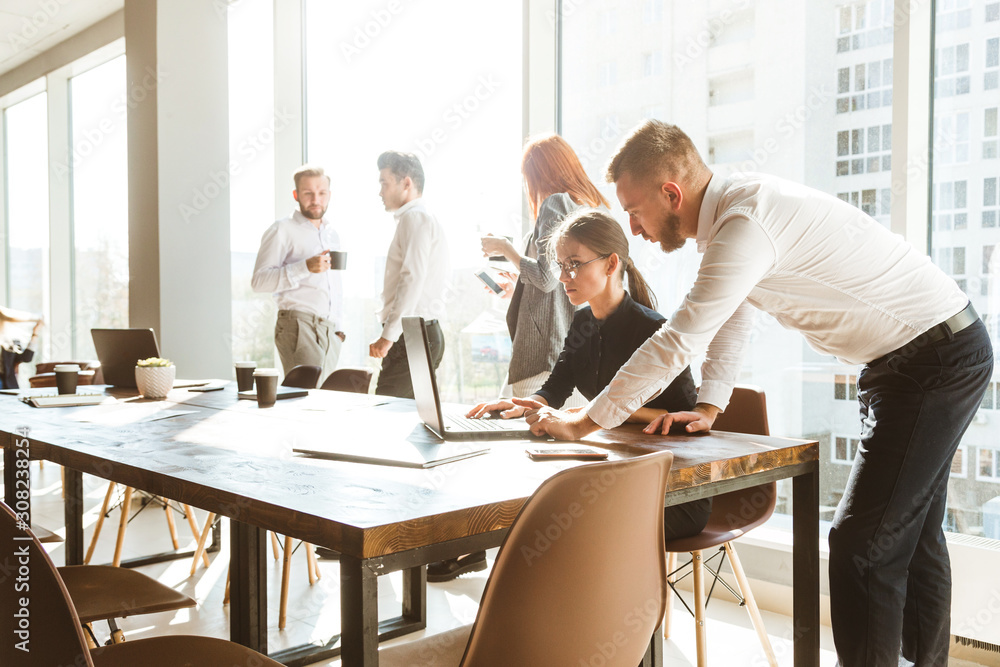 A team of young businessmen working and communicating together in an office. Corporate businessteam and manager in a meeting. A team of young businessmen working and communicating together in an office. Corporate businessteam and manager in a meeting.
