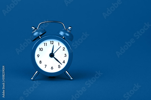 Close up one classic alarm clock over blue background