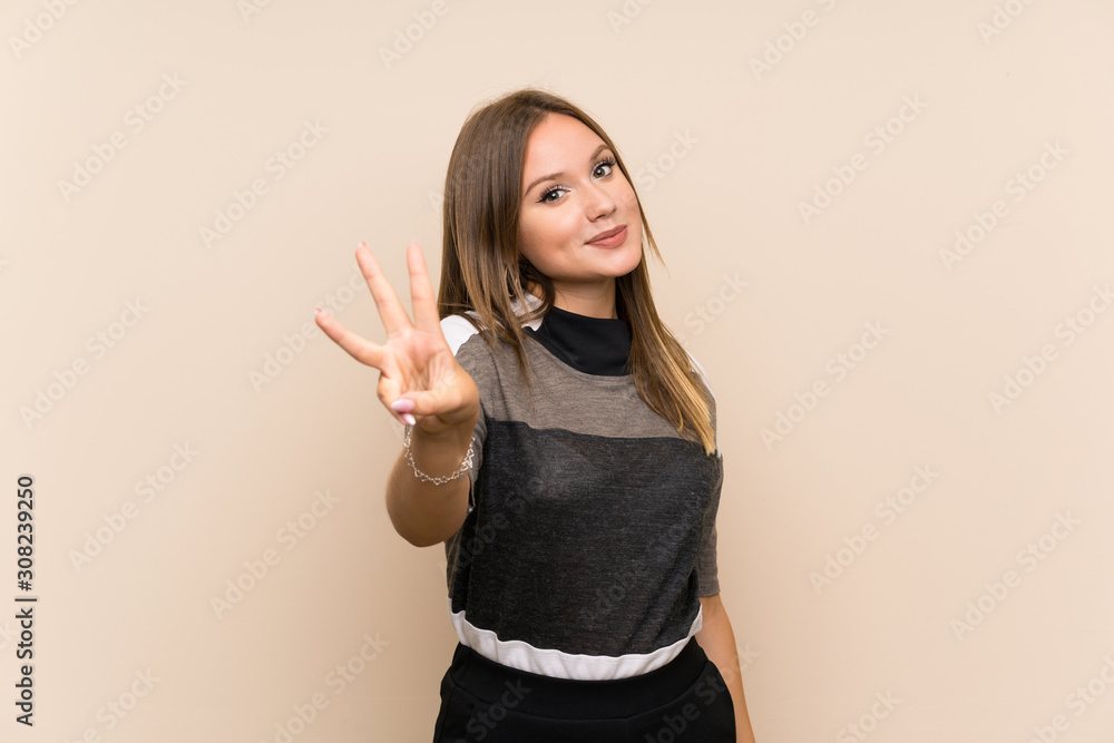 Teenager girl over isolated background happy and counting three with fingers Teenager girl over isolated background happy and counting three with fingers