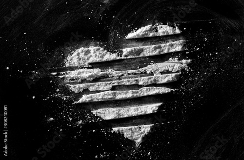 White powder in shape heart, cocaine line isolated on black background, top view, series photo