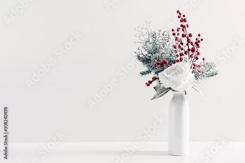 Winter or Christmas composition, decoration, flowers, branches in vase on white background. Christmas home decor, winter concept. Front view, copy space