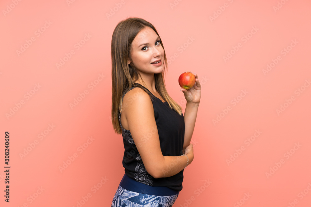 Teenager girl with an apple over isolated background Teenager girl with an apple over isolated background