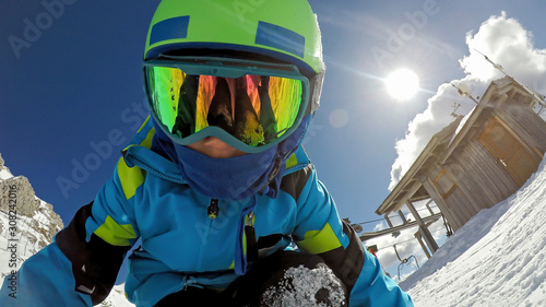 Little boy skiing. Shot of a skier's face..A 6 year old child enjoys a winter holiday in the Alpine resort. .