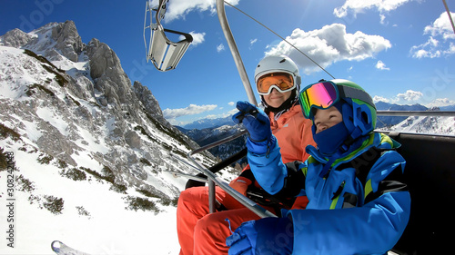 Family on chairlift..The boy and his parents rest on their way to the slopes. .