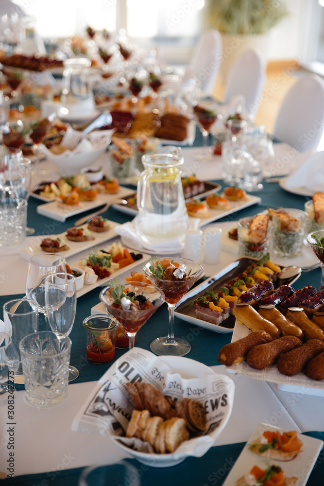 Fototapeta premium Food served on table in a white hall during a Birthday party in Eastern European Baltic Riga Latvia - Blue and teal colors - Canape, snacks and light drinks
