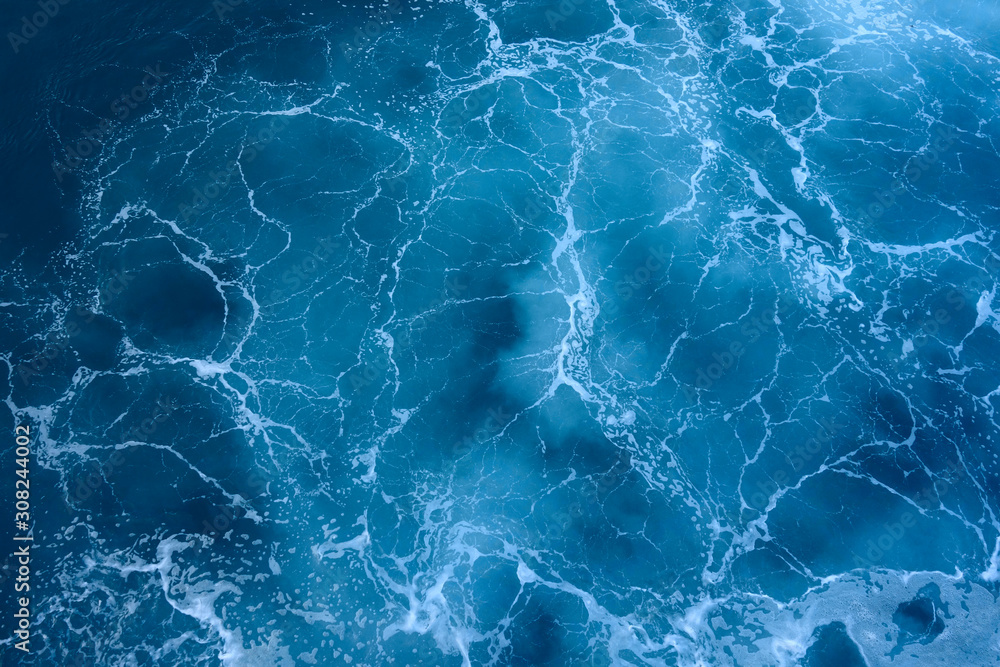 Photo of a sea with foam. Blue surface as background. Photo of a sea with foam. Blue surface as background.