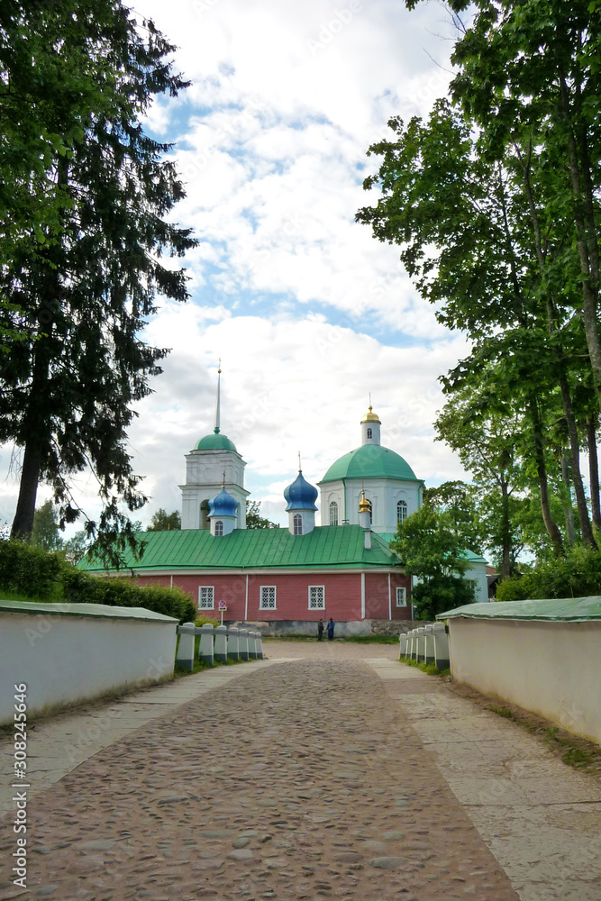 Orthodox Church with green domes. The road paved with cobblestones leading to the temple. Green trees Russia. Summer.