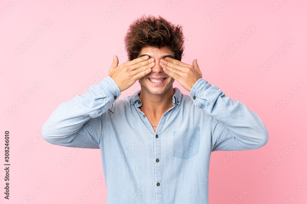 Young caucasian man with jean shirt over isolated pink background covering eyes by hands Young caucasian man with jean shirt over isolated pink background covering eyes by hands