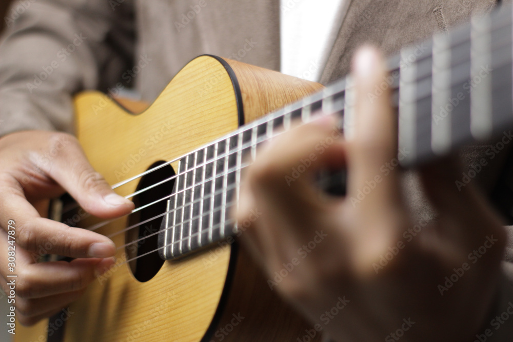 the guitarist is playing an acoustic guitar with blurred background