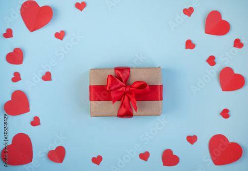 The Background Of Valentine's Day.Gift in a box with a red ribbon, red hearts, a Declaration of love on a light background. The Concept Of Valentine's Day. top view, copy space