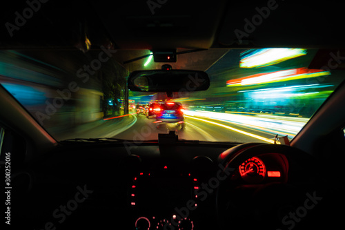 Driving car at night light trail in jakarta city 