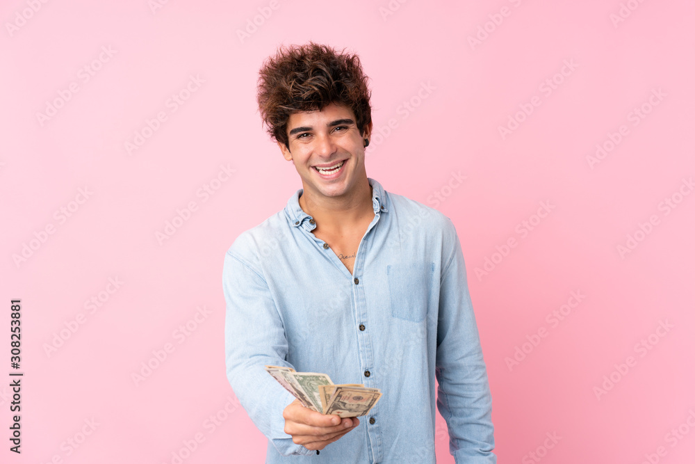 Young caucasian man over isolated pink background taking a lot of money Young caucasian man over isolated pink background taking a lot of money