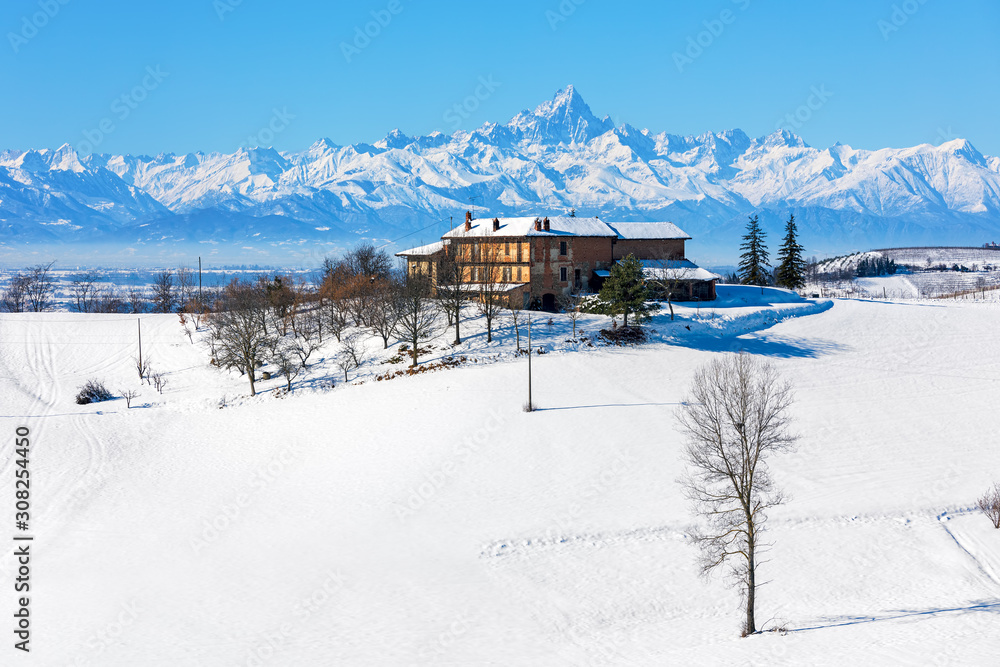 Rural house on snowy hill in Italy.
