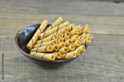 Vanillia waffle roll stick in black bowl on wooden background photo