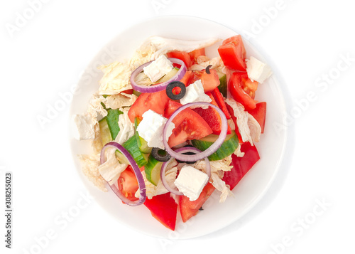 Greek salad. With Peking cabbage, tomato, cucumber, paprika, olives, feta cheese, onions and olive oil. On a white plate. Isolated. On white background. View from above.