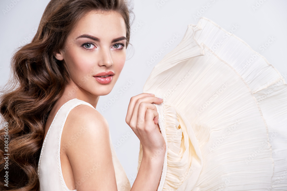 Naklejka premium Portrait of a beautiful woman with a long hair in a beige dress.