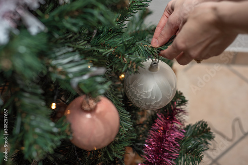Frau schmückt Weihnachtsbaum