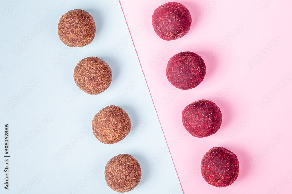 Homemade Raw Vegan Cacao Energy Balls Lie in Row on Trend Blue and Pink Paper Background. Healthy Chocolate Snacks from Nuts and Dates. Concept of Natural Vegetarian Handmade Dessert Homemade Raw Vegan Cacao Energy Balls Lie in Row on Trend Blue and Pink Paper Background. Healthy Chocolate Snacks from Nuts and Dates. Concept of Natural Vegetarian Handmade Dessert