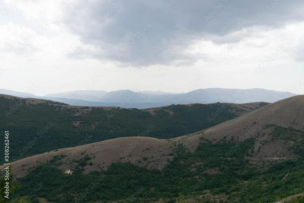 Hilly landscape with mountains in the background Hilly landscape with mountains in the background