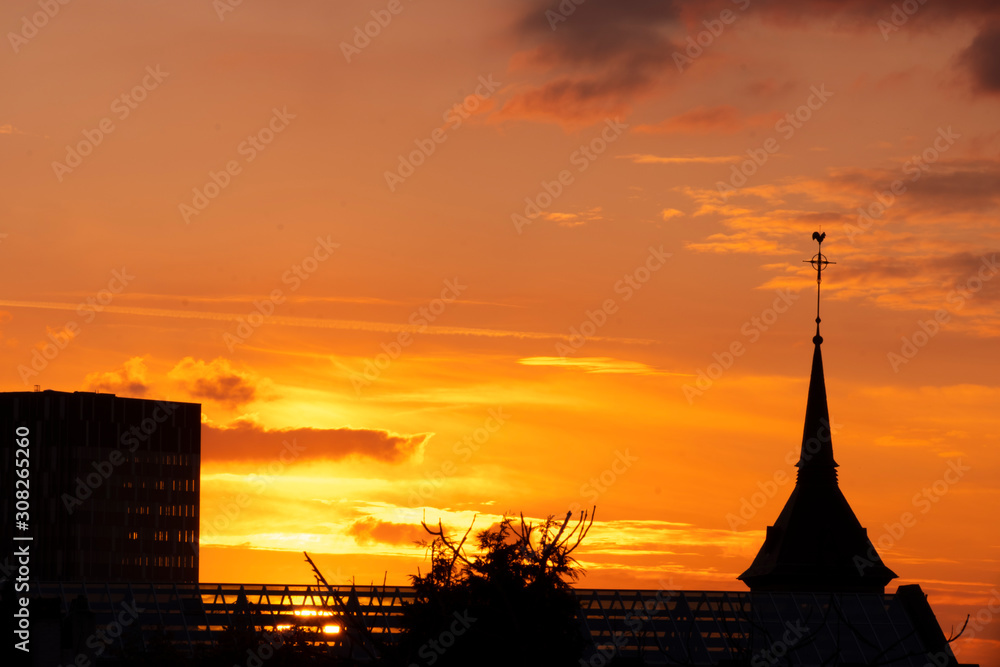 Obraz premium Colorful sky at sunset in Brussels. Church and modern bulding silhouettes