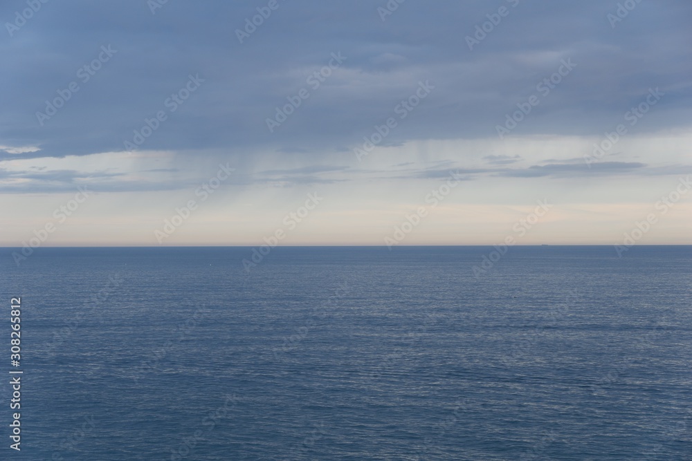 Seascape horizon line with blue cloudy sky. Sunset in Peniscola, Spain