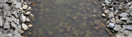 A river that flows through a rocky riverbed. An interesting structure of stones.