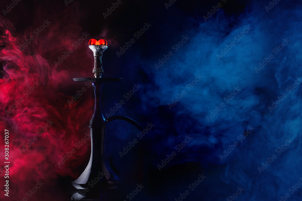 A glossy hookah with burning coal with clouds of red and blue highlighted smoke on black background A glossy hookah with burning coal with clouds of red and blue highlighted smoke on black background