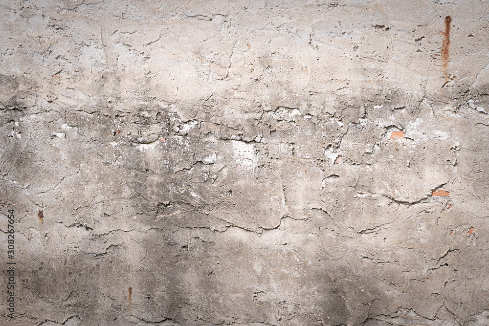 The brick wall is roughly plastered with cement. Revealing the brown brick texture inside. More texture of old dirty concrete wall for background.