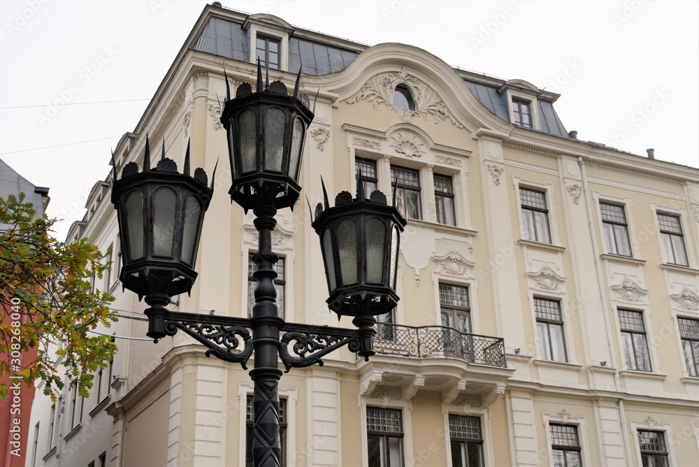Riga, Latvia, November 2019. Beautiful street lamp in the Art Nouveau style on the background of an old house. Riga, Latvia, November 2019. Beautiful street lamp in the Art Nouveau style on the background of an old house.
