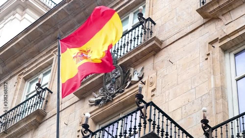 Spanish flag waving by the wind at the entrance of top of governmental building in Madrid. photo