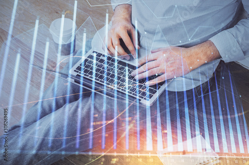 Forex graph with businessman working on computer in office on background. Concept of analysis. Double exposure.