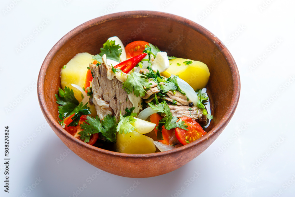Hashlama in a clay plate. Ingredients: Beef ribs, potatoes, herbs, garlic. Hashlama in a clay plate. Ingredients: Beef ribs, potatoes, herbs, garlic.