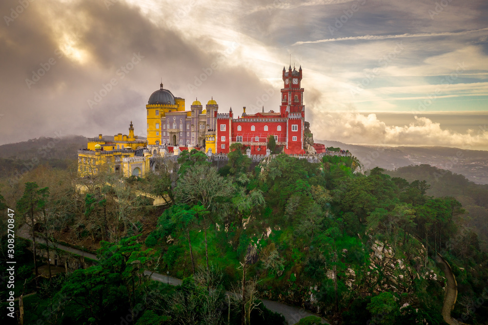 Aerial panorama of Unesco World Heritage Site Pena Palace in Sintra Portugal with colorful yellow and red walls during sunset