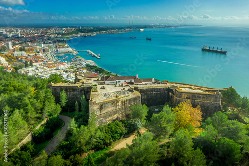 Aerial view of fortress Sao Felipe in Setubal Portugal, star shaped military base protecting the city and the harbor with bastions above the turquoise water of the Atlantic ocean and the Sado estuary