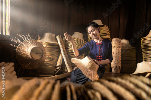 Young women are weaving in field handmade basket of Thailand.
