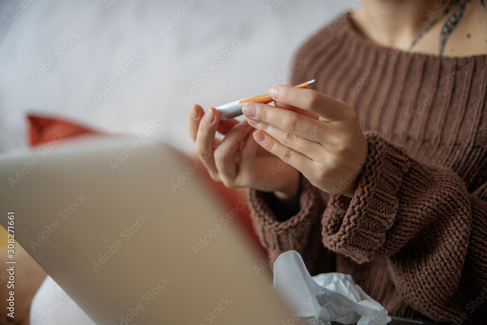 Close up of woman hands with thermometer