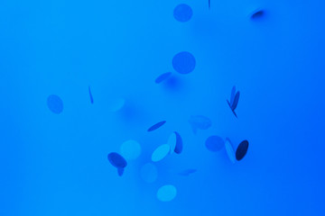 Blue confetti on blue background. Trendy classic blue tinting