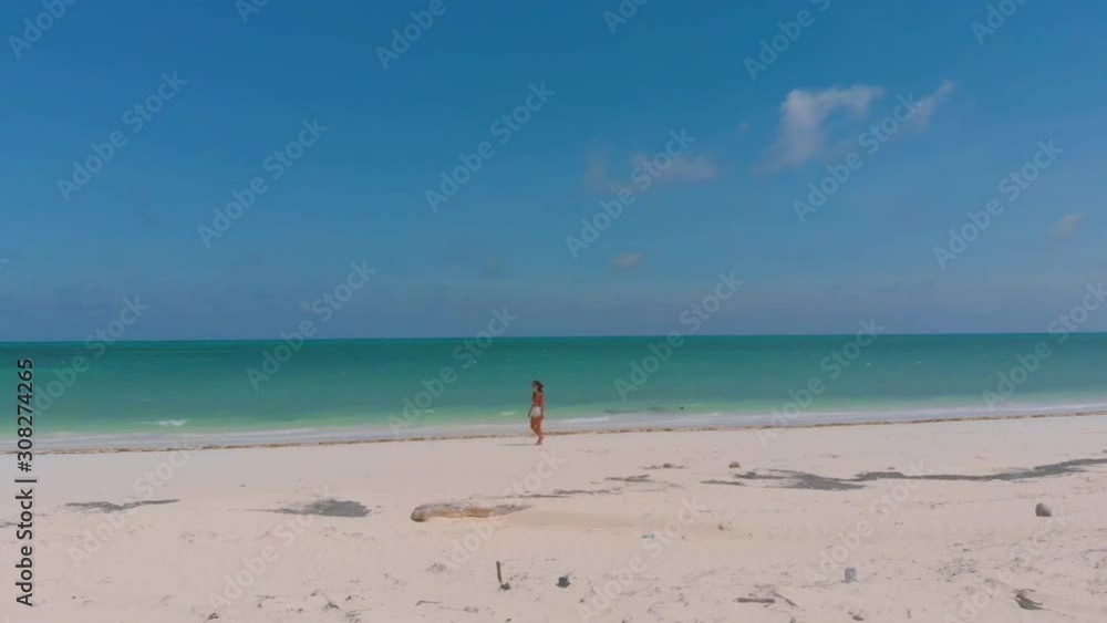 Aerial view of woman alone on the white sandy beach at Punta Sebaring in Bugsuk Island in Balabac, Palawan, Philippines Aerial view of woman alone on the white sandy beach at Punta Sebaring in Bugsuk Island in Balabac, Palawan, Philippines