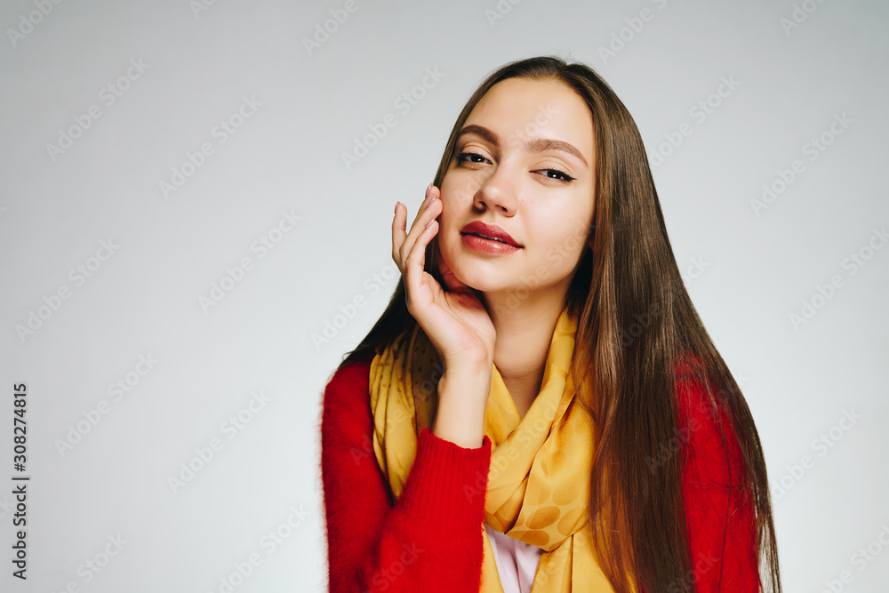 The girl propping her hand on her cheek, slightly narrowed her eyes and with a slight smile piercingly looks into the camera The girl propping her hand on her cheek, slightly narrowed her eyes and with a slight smile piercingly looks into the camera