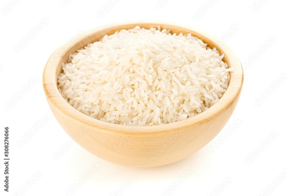 Heap of white uncooked, raw long grain rice in wooden bowl on white Heap of white uncooked, raw long grain rice in wooden bowl on white
