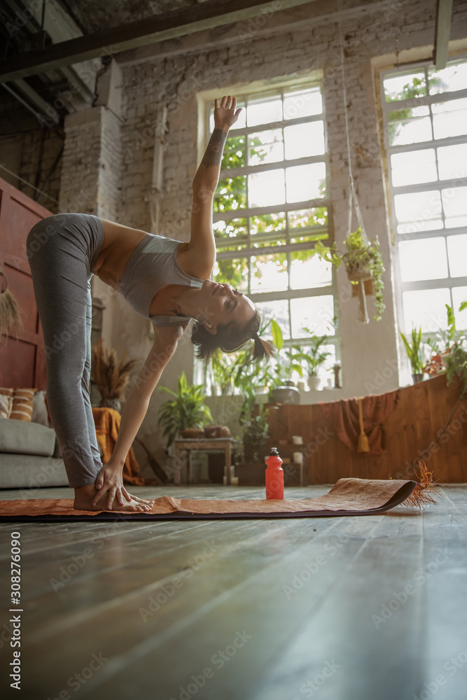 Pretty young lady doing yoga exercise at home - obrazy, fototapety, plakaty 