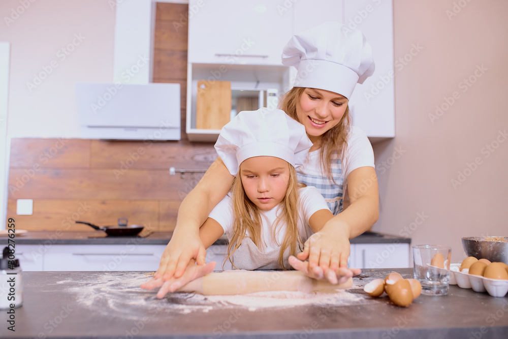 family concept. young caucasian mother teaching her child girl to bake, to cook. Little kid girl help mother in kitchen