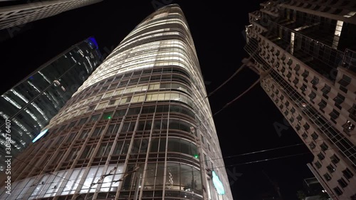 Orbiting shot on ground level of a high rise building in downtown San Francisco at night