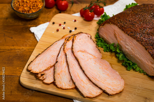 Roasted Turkey Breast Cajun Style Deli Lunch Meat on Old Wooden Background. Selective focus.