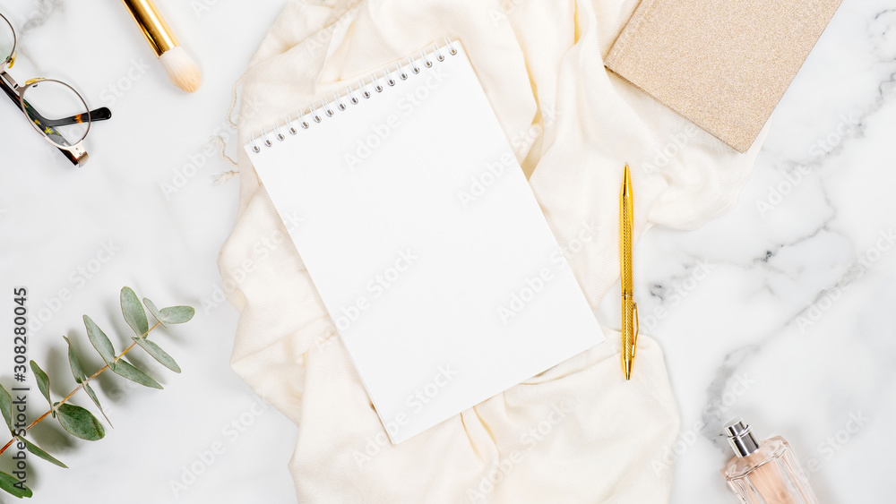 Feminine home office desk with blank paper notepad, cosmetic and fashion accessories. Flat lay, top view. Feminine home office desk with blank paper notepad, cosmetic and fashion accessories. Flat lay, top view.