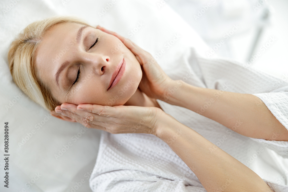 Happy adult woman touching face be hands Happy adult woman touching face be hands