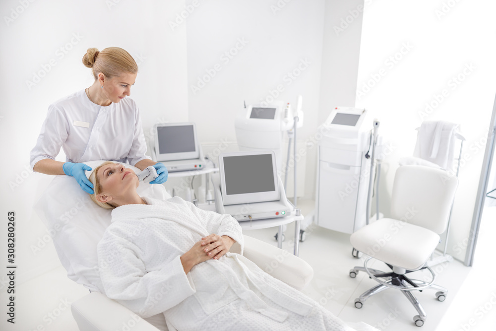 Obraz premium Specialist making facial procedures in beauty salon