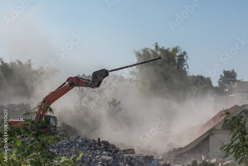 Foto Excavator demolishing house on construction site